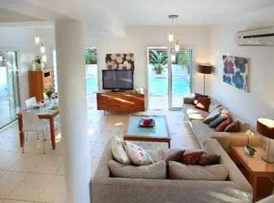 a living room with a couch and a table and a television at Villa Kos 19 in Protaras