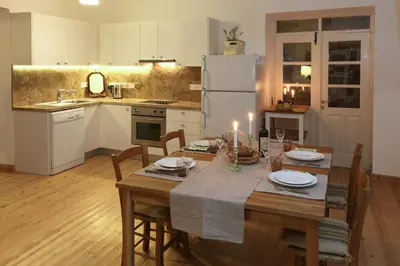 a kitchen with a table and a white refrigerator at Kalopanayiotis Cottage in Kalopanayiotis