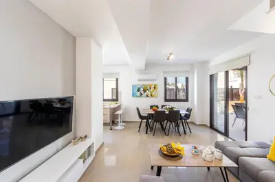 a living room with a couch and a table at Protaras Villa Angela Nefeli in Paralimni