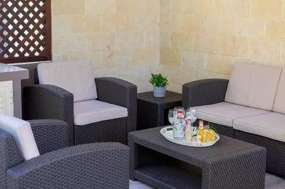 a group of chairs and tables on a patio at Protaras Villa Angela Nefeli in Paralimni