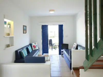 a living room with two blue couches and a doorway at Villa Julie in Protaras