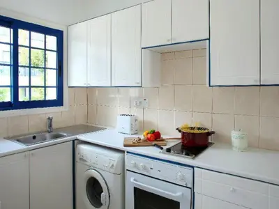 a white kitchen with a dishwasher and a sink at Villa Julie in Protaras