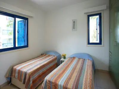 two beds in a room with two windows at Villa Julie in Protaras