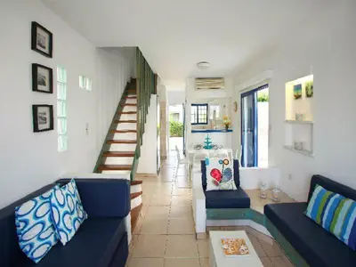 a living room with blue couches and a staircase at Villa Julie in Protaras