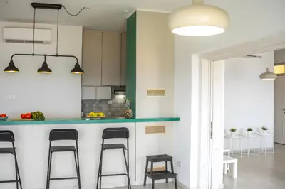 a kitchen with a counter and stools in a room at Protaras H2O Seafront Suite in Protaras