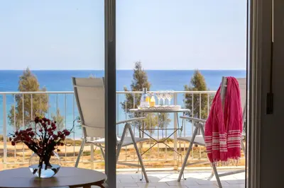 a balcony with a table and chairs and the ocean at Protaras H2O Seafront Suite in Protaras