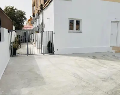 a white building with a gate and a window at Larnaca - Studio - Sleeps 4 - Garden - Parking in Larnaka