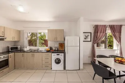a kitchen with a white refrigerator and a table at Nissini villa in Ayia Napa