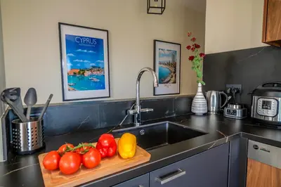 a kitchen with a sink and a cutting board with tomatoes at Perfect for families, Beach 3 Min away, Brand New in Limassol