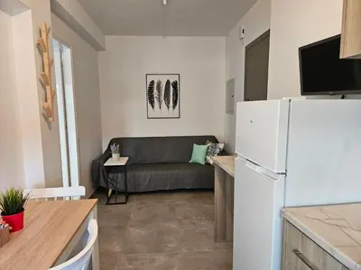 a living room with a couch and a white refrigerator at SC_apartments in Kato Pyrgos