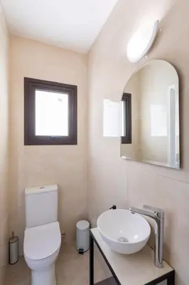 a bathroom with a toilet and a sink and a mirror at Epicurian Residence in Nicosia