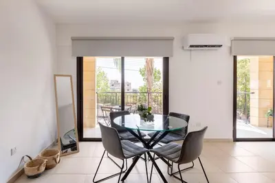 a dining room with a glass table and chairs at Epicurian Residence in Nicosia