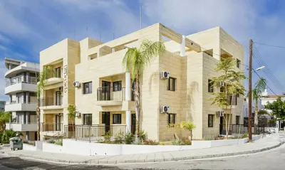 a large building with palm trees in front of it at Epicurian Residence in Nicosia