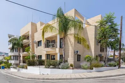 a building with palm trees in front of it at Epicurian Residence in Nicosia