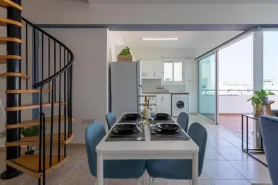 a dining room and kitchen with a table and chairs at Chloris 3- Bedroom Apartment W/Pool in Larnaca in Larnaka