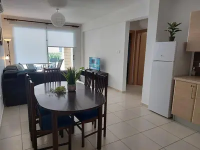 a kitchen and dining room with a table and chairs at Pyla Palms Resort B1 - 1 in Larnaka