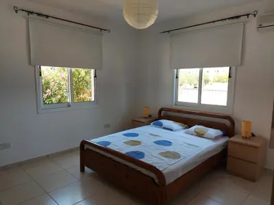 a bedroom with a bed and two windows at Pyla Palms Resort B1 - 1 in Larnaka