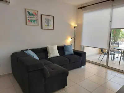 a living room with a black couch and a table at Pyla Palms Resort B1 - 1 in Larnaka