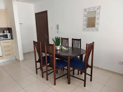 a dining room table and chairs with a plant on it at Pyla Palms Resort B1 - 1 in Larnaka