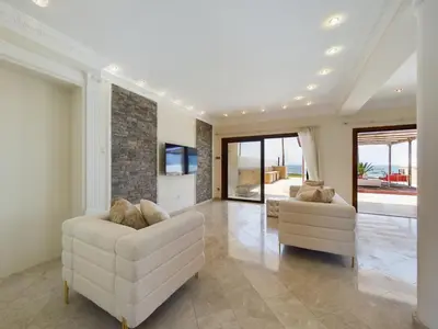 a living room with two couches and a tv at Fabulous beach front house with pool in Larnaka