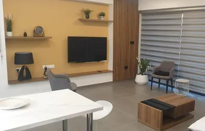 a living room with a tv and a table and chairs at New Smart Living-1 Bedroom Aglantzia, Nicosia in Aglantzia