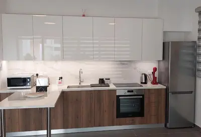 a kitchen with white appliances and wooden cabinets at New Smart Living-1 Bedroom Aglantzia, Nicosia in Aglantzia