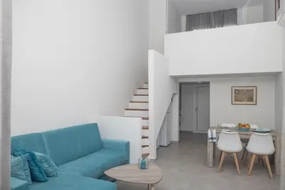 a living room with a blue couch and a table at Lovely Studio by the Beach in Voroklini