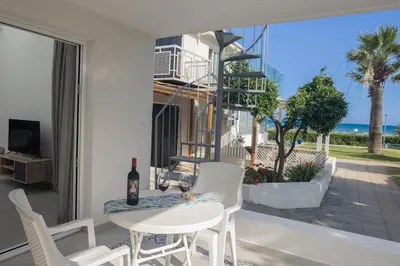 a white table and chairs on a balcony with a view of the ocean at Lovely Studio by the Beach in Voroklini