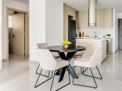 a kitchen with a black table and white chairs at Sanders Premier Downtown in Limassol