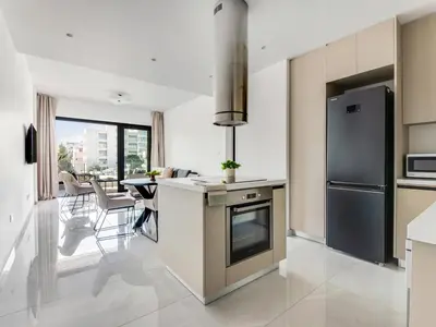 a kitchen with a stainless steel refrigerator and a table at Sanders Premier Downtown in Limassol