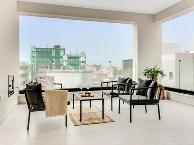 a living room with chairs and a table and a large window at Sanders Premier Downtown in Limassol