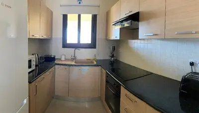 a kitchen with wooden cabinets and a sink at Quiet kykladesAG10/near the beach, Paralimni in Paralimni
