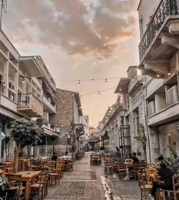 an empty street with tables and chairs and buildings at Cozy house city center in Limassol in Limassol