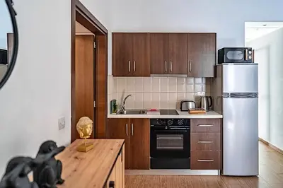 a kitchen with wooden cabinets and a white refrigerator at Cozy house city center in Limassol in Limassol