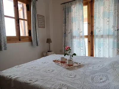 a white bed with two candles and flowers on it at The House of Pericles in Silikou