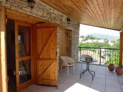 a room with a wooden door and a table on a balcony at The House of Pericles in Silikou
