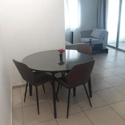 a dining table and chairs in a living room at A CHEERFUL APARTMENT in a popular area in Pallouriotissa