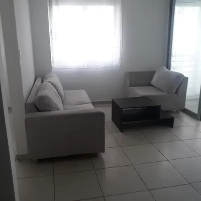 a living room with a couch and a coffee table at A CHEERFUL APARTMENT in a popular area in Pallouriotissa