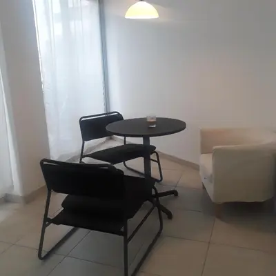 a room with a table and two chairs and a couch at A CHEERFUL APARTMENT in a popular area in Pallouriotissa