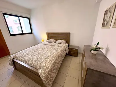 a bedroom with a large bed and a window at Mackenzie apartment 301 in Larnaka