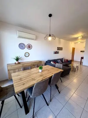 a living room with a wooden table and a couch at Mackenzie apartment 301 in Larnaka