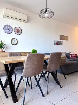 a dining room with a wooden table and chairs at Mackenzie apartment 301 in Larnaka