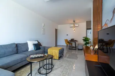 a living room with a blue couch and a table at Flair - 1-Bedroom Apartment & Balcony in Larnaca in Larnaka