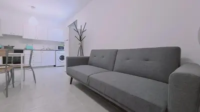 a living room with a couch and a kitchen at STAY Sand Flat in Paralimni