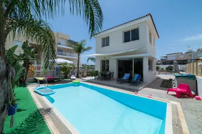 a villa with a swimming pool in front of a house at Villa Anna Maria, Kapparis in Paralimni