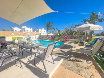 a patio with a table and chairs and a pool at Villa Anna Maria, Kapparis in Paralimni