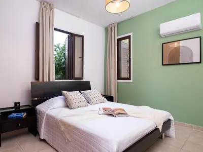 a bedroom with a bed with a book on it at Cute & Cozy Mazotos 1bed Getaway in Mazotos