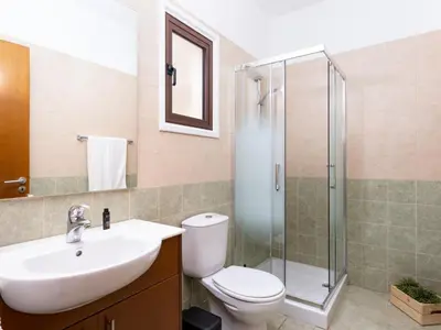 a bathroom with a toilet and a sink and a shower at Cute & Cozy Mazotos 1bed Getaway in Mazotos