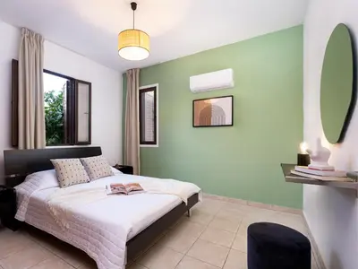 a bedroom with a bed and a green wall at Cute & Cozy Mazotos 1bed Getaway in Mazotos
