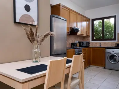 a kitchen with a table with chairs and a refrigerator at Cute & Cozy Mazotos 1bed Getaway in Mazotos